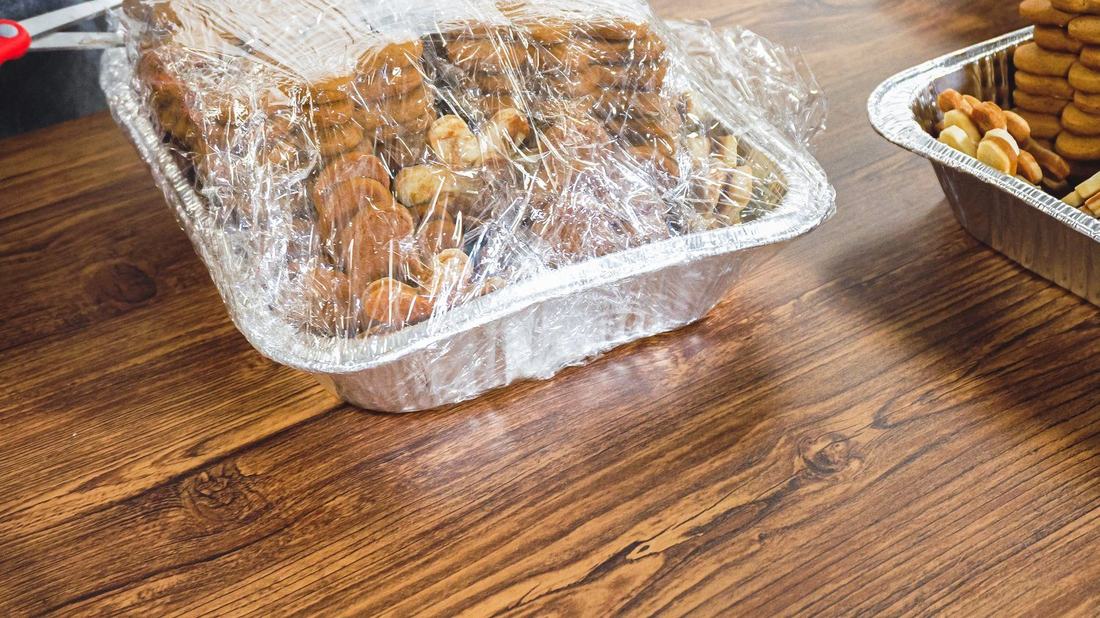 Tace z jedzeniem przykryte folią na blacie kuchennym